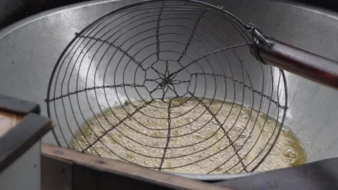 Close up of deep frying traditional snacks or dough sticks in bubbling hot cooki Stock Footage 337871980
