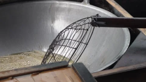 Close up of deep frying traditional snacks or dough sticks in bubbling hot cooki Stock Footage 337871996