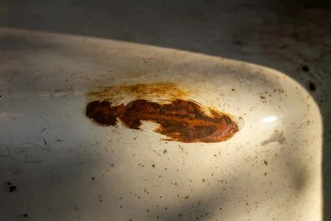 Close-up of a deep rust patch on an old weathered white metal surface Stock Photos