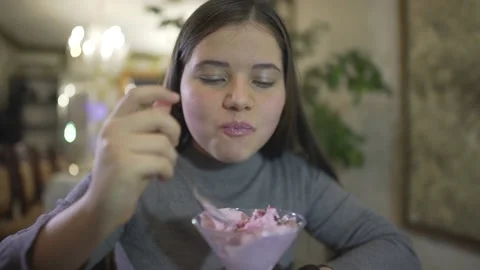 Close up defocused view on chubby brunette little teenage girl eating violet col Stockbeeldmateriaal 137538363