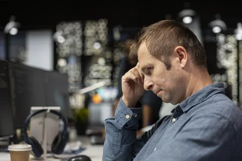 Close up of dejected man in startup office bummed after noticing error in code Foto stock