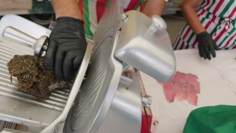 Close-up of a deli slicer blade slicing cured meat at a market stall, Cote Stock Footage 344829056