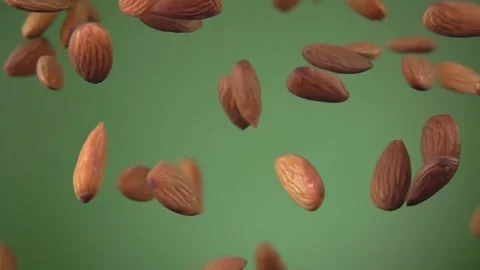 Close-up of delicious almonds bouncing and rotating on olive green background Stock Footage 255702777