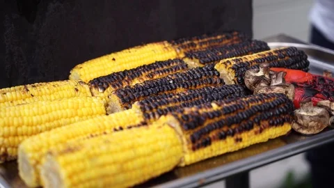 Close up delicious BBQ corn on cob grilling over glowing coals. Stock Footage 111346236