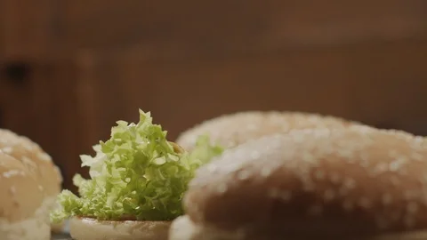 Close-up of delicious beef cutlet drops on hamburger with sauce and lettuce Stock Footage 124073954