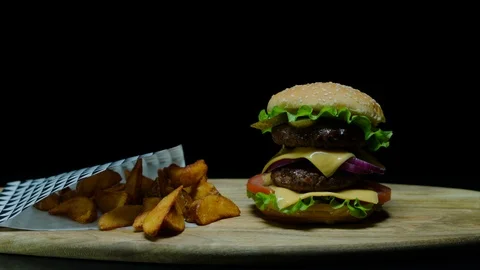 Close up of delicious burger with double cheese and french fries. Black Stock Footage 92486038
