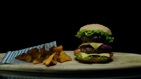 Close up of delicious burger with double cheese and french fries. Black Stock Footage 92487394