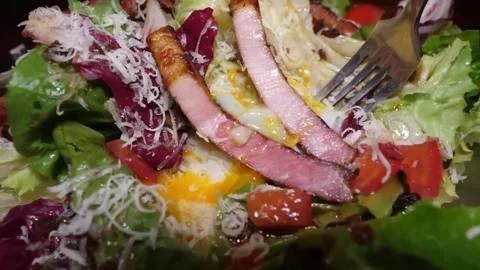 Close-up of a Delicious Caesar Salad with Bacon and Egg Yolk 스톡 동영상 332817760