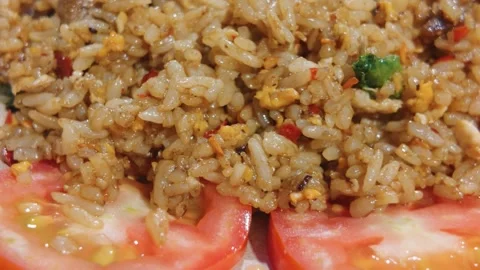 Close up of delicious fried rice garnished with fresh sliced tomatoes. Video stock 343411819