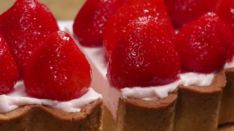 Close-up of a delicious fruit tart with fresh strawberries and pink cream fillin Stock Footage 337751292