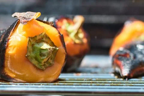 Close-up of delicious grilled bell peppers cooking on a hot metal barbecue .. 库存照片