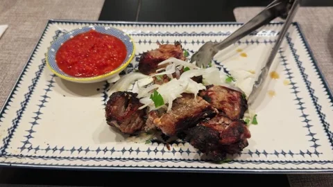Close-up of delicious grilled kebabs cooked on a barbecue served with herbs with Stock Footage 304177933