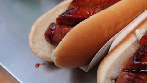 Close-Up of a Delicious Grilled or BBQ Sausage in a Hot Dog Bun Stock Footage 331955617