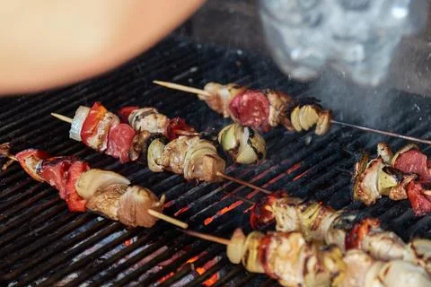 Close-up of delicious meat and vegetable skewers grilling on a hot barbecue.. Stock Photos
