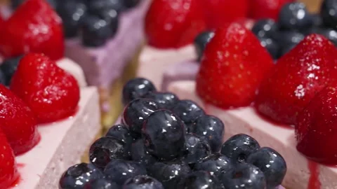 Close up of delicious mixed berry cheesecake slices topped with fresh glazed str Stock Footage 337751282