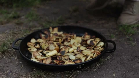 Close-up of delicious roasted potatoes cooking in a cast iron skillet outdoors Stock Footage 337106452