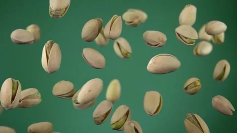 Close-up of delicious salted Pistachios bouncing on a green background Stock Footage 230506339