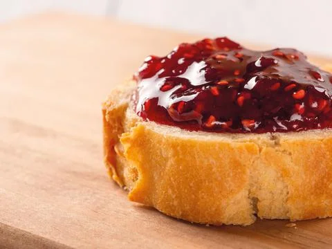 Close-up of delicious sandwich with raspberry jam on a wood cutting board. Stock Photos