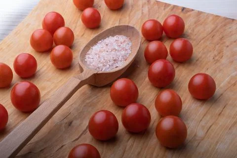 Close-up of delicious small red cherry tomatoes around a large wooden spoon w 스톡 사진