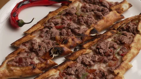 Close-up of a delicious Turkish pide with minced meat, served with red pepper Stock Footage 339121364