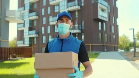 Close up Delivery man holding cardboard box at street wear protective medical Stock Footage 133014796