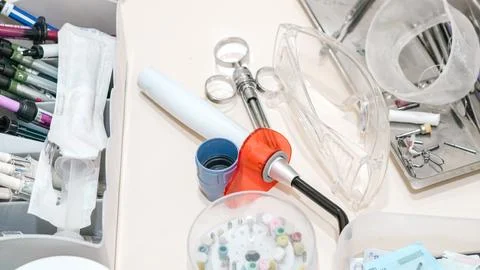 Close up of dental tools, a curing light, syringes, and safety glasses on a t Stock Photos