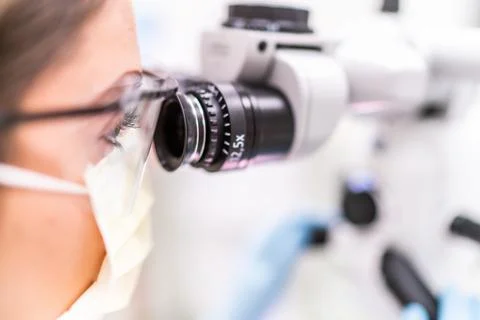 Close up dentist looking through microscope Stock Photos