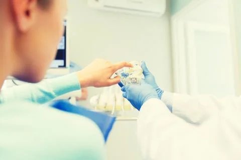 Close up of dentist with teeth model and patient Stock Photos