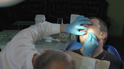 Close-Up of Dentist Using Dental Tool Gives Shape to the Seal Composite Material Stock Footage 76556390