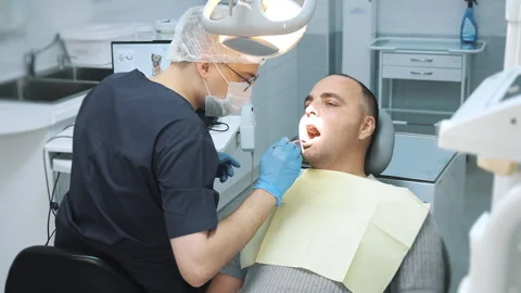 Close-up of the dentists hand treating teeth of a man in clinic. Stock Footage 317295845