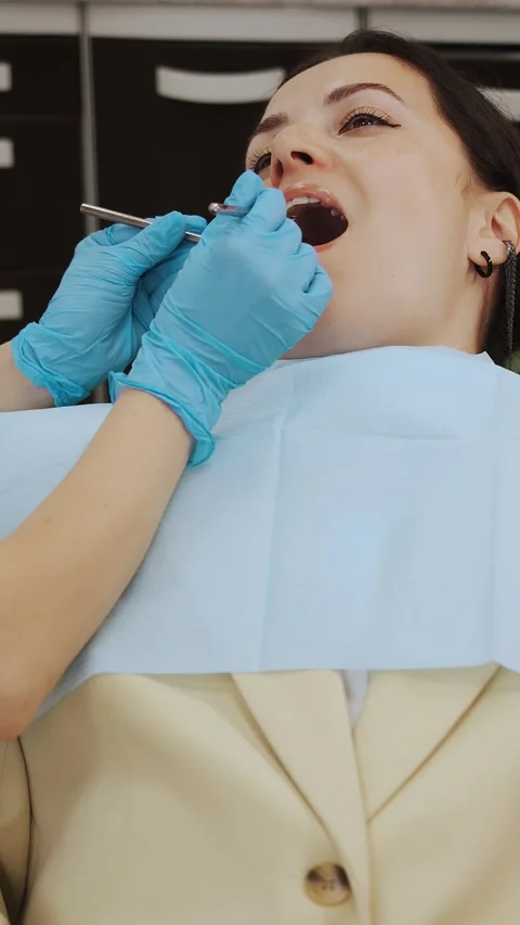Close-up of the dentists hand treating teeth of a little girl in clinic. Stock Footage 317797409