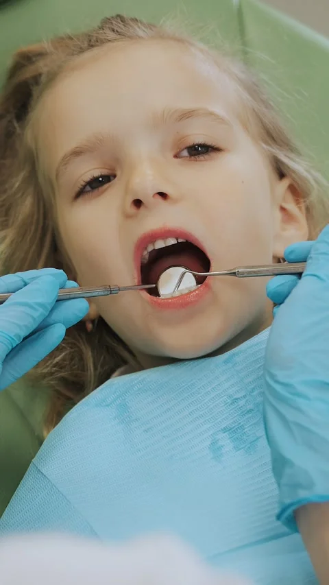 Close-up of the dentists hand treating teeth of a little girl in clinic. Stock Footage 317797733
