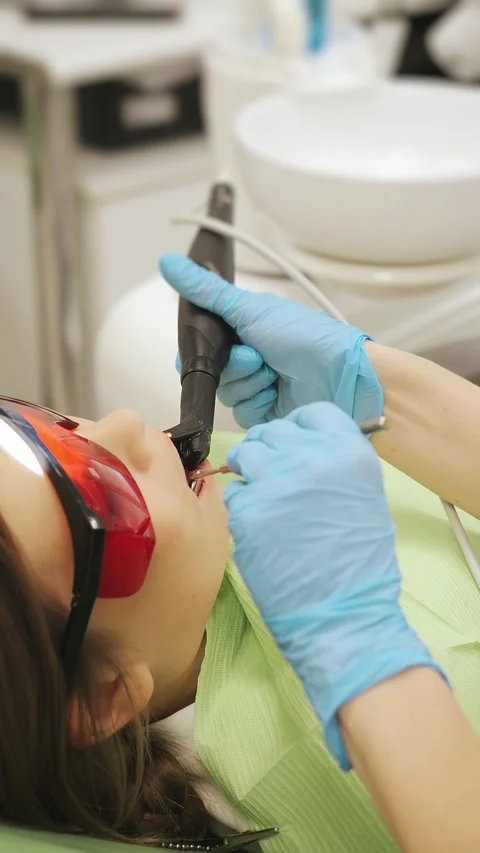 Close-up of the dentists hand treating teeth of a little girl in clinic. Stock Footage 317865939