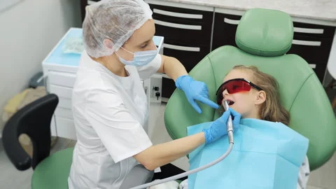 Close-up of dentists hands cleaning little girls teeth in modern clinic. Video stock 317246778