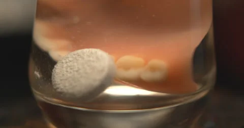 Close of denture cleaning tablet dropping into a glass of dentures Stock Footage 154809107