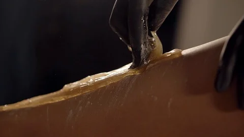 Close-up of depilation of legs by sugar paste in beauty salon Stock-Footage 89997092