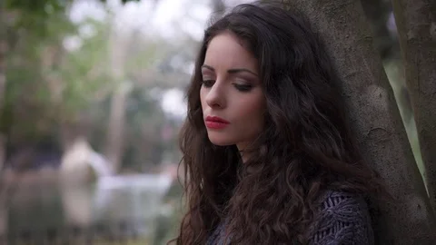 Close up on depressed and sad Young beautiful woman at the park Stock Footage 74722778