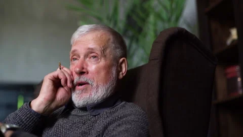 Close-up of depressed gray-haired older man talking about his problems while Video stock 136506748