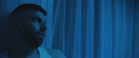 Close up of a depressed man sitting on a bed, staring at the ceiling. Stock Footage 147537216