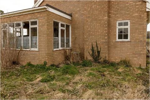 Close up of a derelict building with corrugated sheets covering broken window Stock Photos