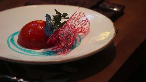 Close up of a deserd served on a white plate with a strawberry sauce. Video stock 70394655