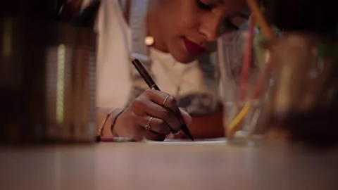Close-up of a designer using a pencil and a sheet of paper to make fashion sk Stock Footage 152344949