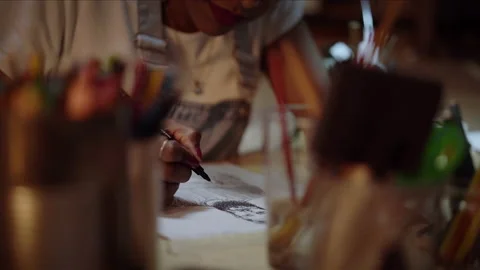 Close-up of a designer using a pencil and a sheet of paper to make fashion sk Stock Footage 152344958