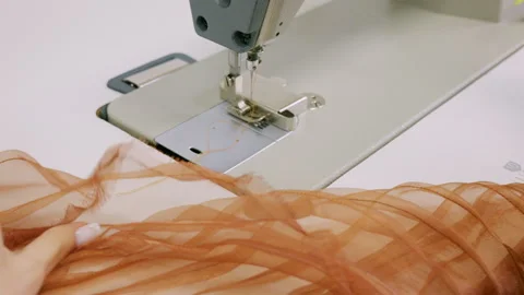 Close up of a designer's hands cutting mustard sewing thread with small red Stock Footage 335505468