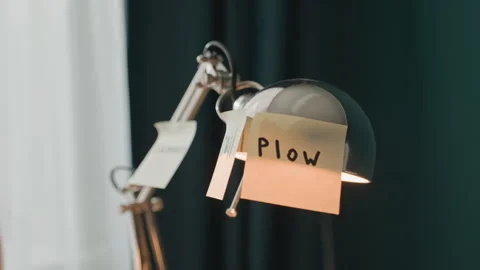 Close up of desk lamp with sticky notes labeled plow and another note against Stock Footage 344403999
