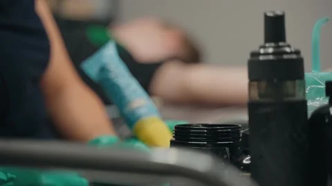 Close-up from desktop tattoo master gain paint in machine and get to work. Stock Footage 219549207
