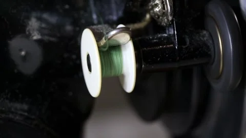 Close up detail of green thread bobbin winding process on vintage sewing machine Stock Footage 329213259