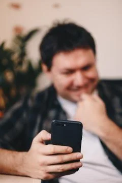 Close up detail of a man's hand using a smartphone to take a selfie, while si Stock Photos