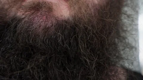Close-Up Detail of a Man's Thick, Dark, and Untrimmed Beard Showcasing Natural Stock Footage 329939032