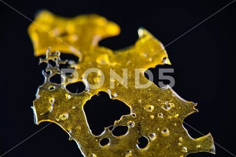Close up detail of marijuana oil concentrate aka shatter isolated Stock Photos